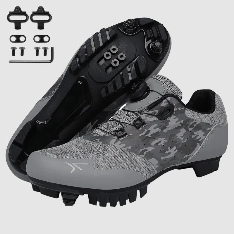 Gray and black cycling shoes with cleats on a white background